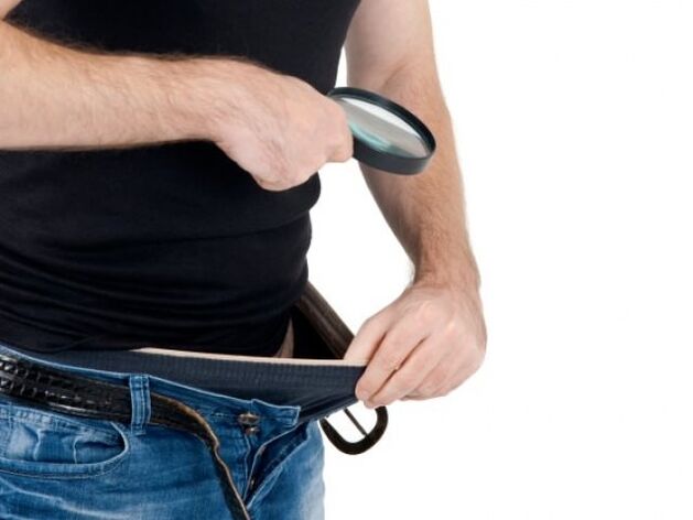 мъж гледа надолу по панталоните си и иска да увеличи пениса си